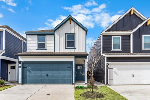A row of houses with garages and driveways.