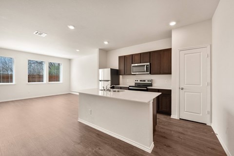 A kitchen with a white counter and brown cabinets.