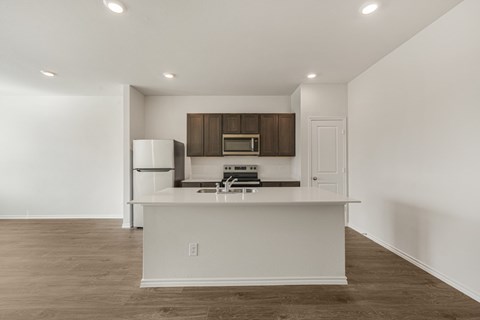 A kitchen with white cabinets and a white island.