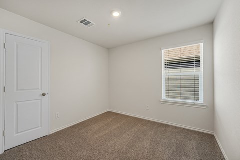 A room with a white door and a window with blinds.