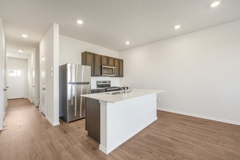 A kitchen with a white counter and stainless steel appliances.