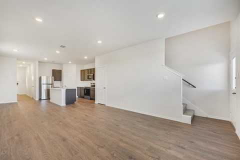 A spacious room with wooden floors and white walls.