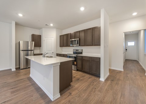 A kitchen with brown cabinets and a white island.
