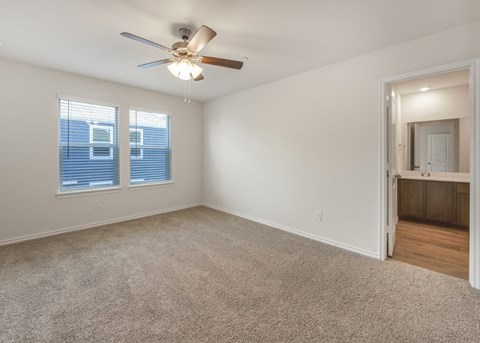 A room with a ceiling fan and carpeted floor.