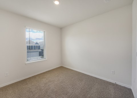 A room with a window and carpeted floor.