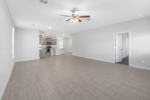 A spacious room with a ceiling fan and lighting fixtures.