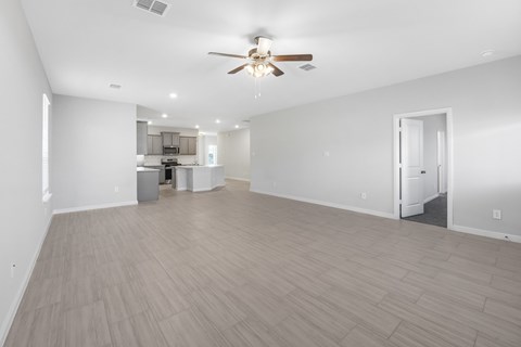 A spacious room with a ceiling fan and lighting fixtures.