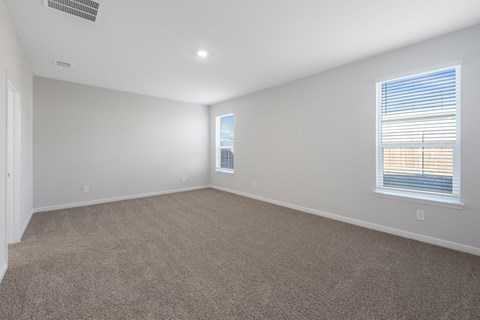 A room with a window and a carpet on the floor.