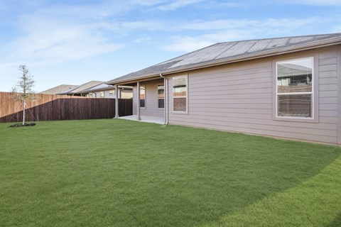 A house with a grey roof and a green lawn.