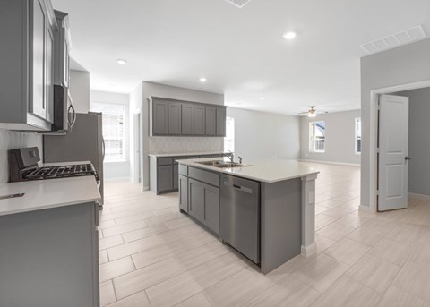 A modern kitchen with a large island and stainless steel appliances.
