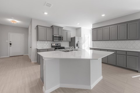 A modern kitchen with a white island and wooden floors.