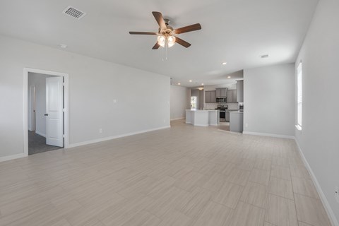 A spacious room with a ceiling fan and lighting fixtures.