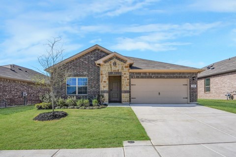 A house with a brick facade and a large front yard.