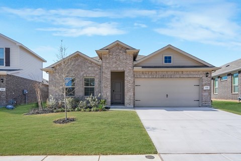 A house with a grey garage door and a brown stone facade.