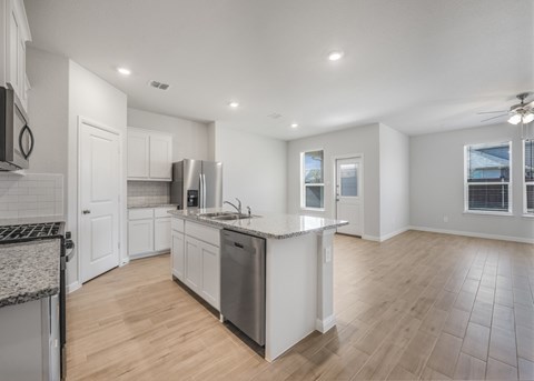 A modern kitchen with white cabinets and stainless steel appliances.