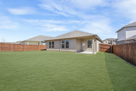 A house with a green lawn in front of it.