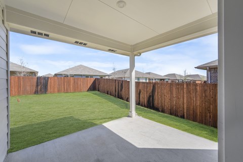 A patio with a white roof and a wooden fence.