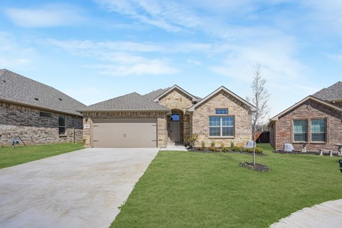 A house with a stone wall and a garage door.