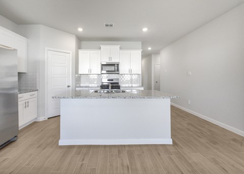 A modern kitchen with a white island in the middle.