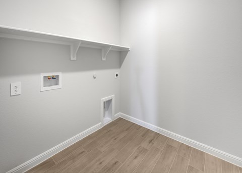 A white wall with a picture frame and a light switch.