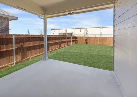 A patio with a white roof and a wooden fence.