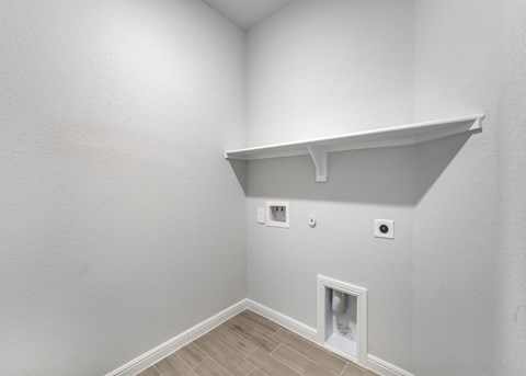 A white room with a shelf and a vent.