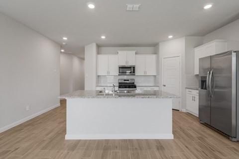A modern kitchen with white cabinets and a central island.