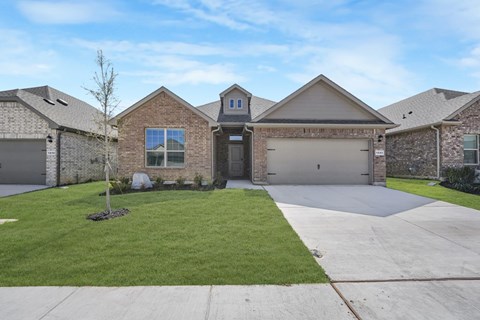 A house with a grey garage door and a black door.
