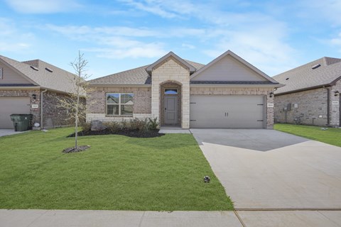 A house with a grey garage door and a brown roof.