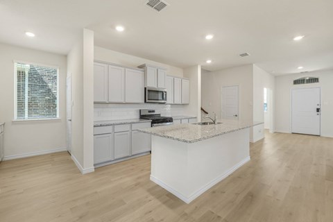 A kitchen with white cabinets and a granite countertop.