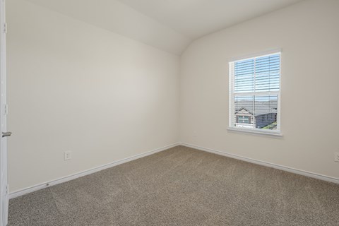 A room with a window and a view of a building outside.