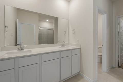 A bathroom with two sinks and a large mirror.