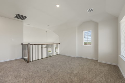 A spacious room with a carpeted floor and a window with blinds.