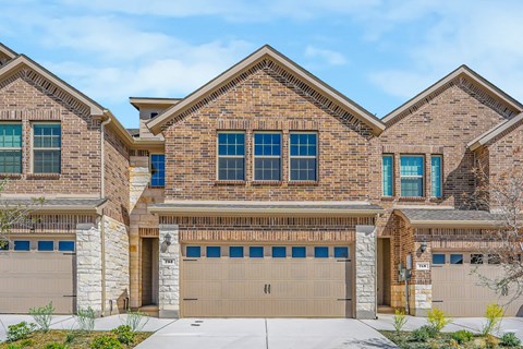 A large brick house with two garages.