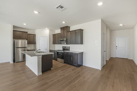 A modern kitchen with wooden floors and white walls.