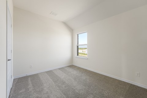 A room with a carpeted floor and a window.