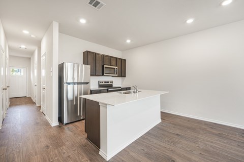 A modern kitchen with a white island and stainless steel appliances.