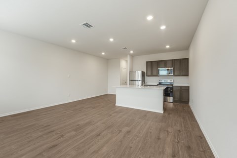 A kitchen with a white counter and wooden flooring.