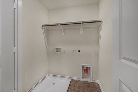 A white closet with a shelf and a white door.