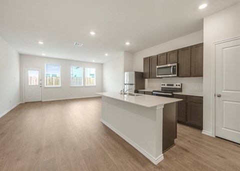 A kitchen with a white countertop and brown cabinets.