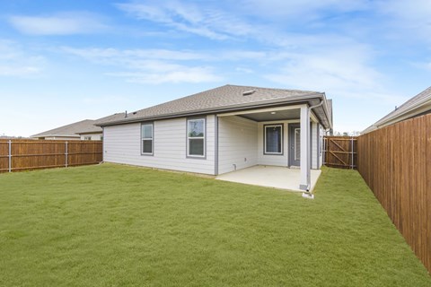 A house with a grey roof and a white wall with a small window.