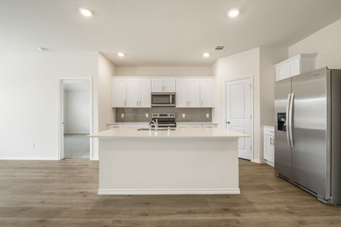 A modern kitchen with white cabinets and a large island.