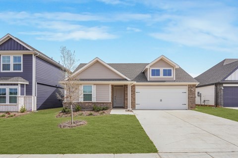 A house with a grey roof and a white garage door.