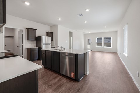 A modern kitchen with dark wood cabinets and stainless steel appliances.