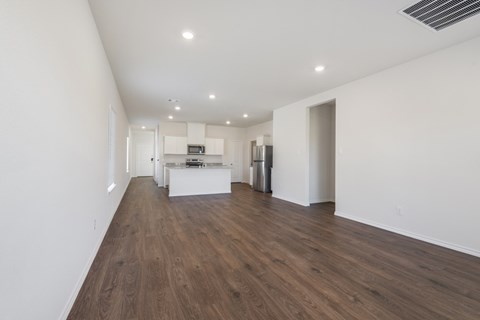 A spacious room with wooden floors and white walls.