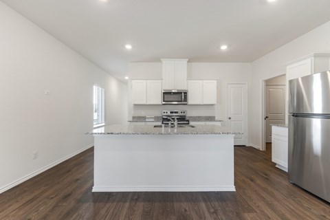 A modern kitchen with white cabinets and a stainless steel refrigerator.