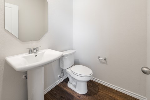 A white toilet sits next to a sink in a bathroom.
