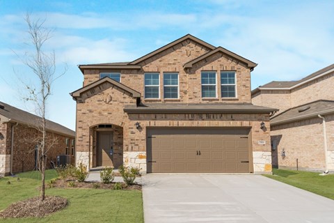 A house with a brown garage door is surrounded by a well-maintained lawn.