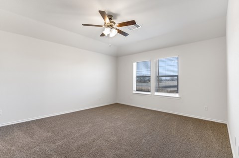 A room with a ceiling fan and carpeted floor.