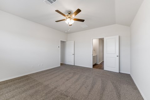 A room with a ceiling fan and carpeted floor.